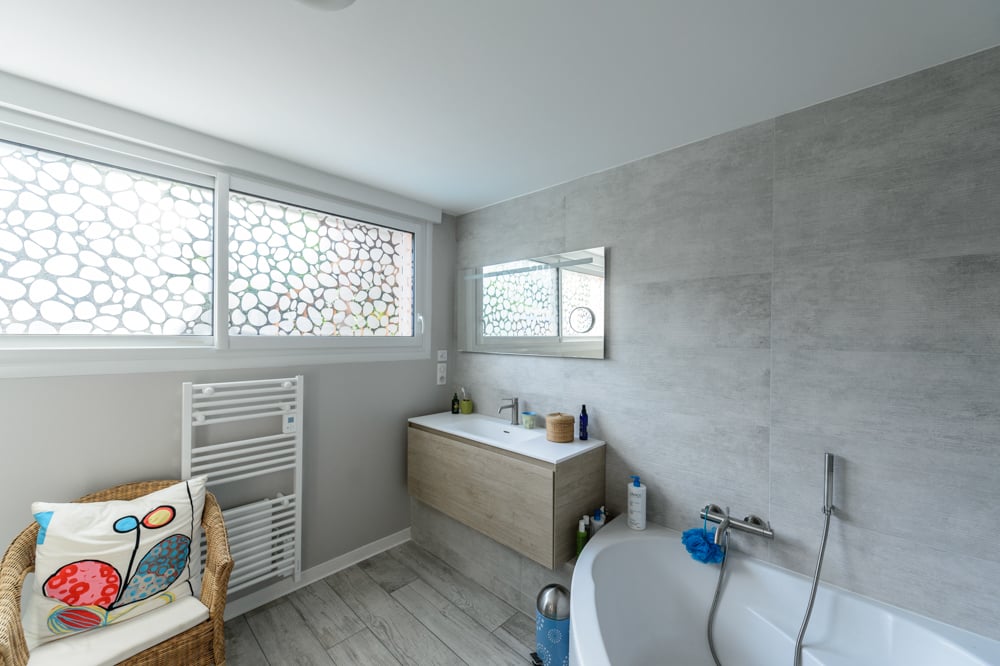 03-apres-meuble-vasque-angle-baignoire-douchette-robinetterie-seche-serviette-fenetre-coulissante-miroir-peinture-claire